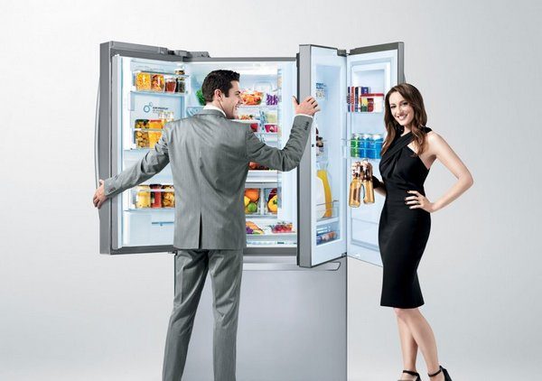  Hombre y mujer están parados cerca del refrigerador.