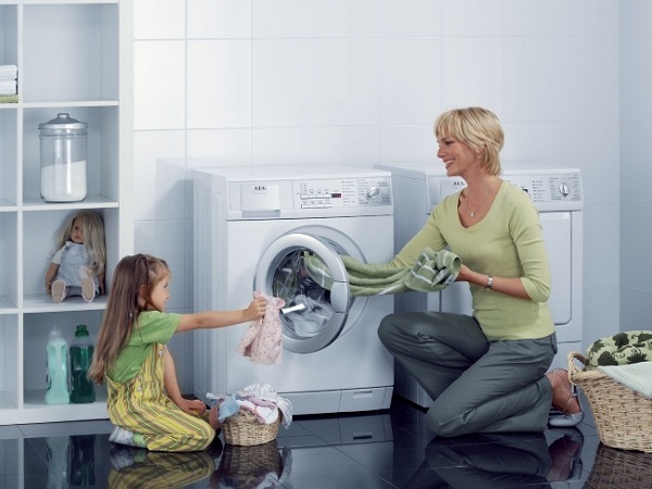  Madre e hija cerca de la lavadora