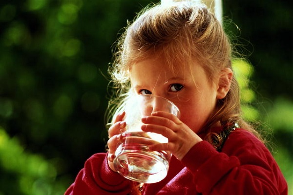  El niño bebe agua de un vaso.