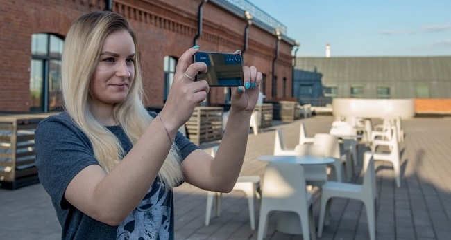  Chica toma una foto con un teléfono inteligente